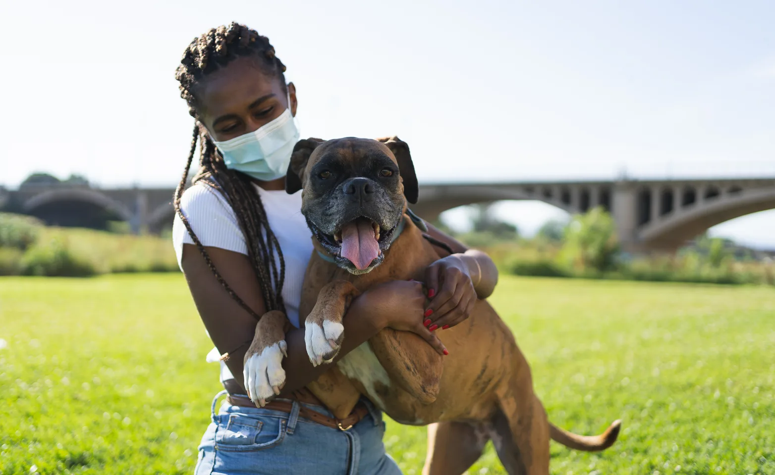 Girl wearing a mask and holding a dog